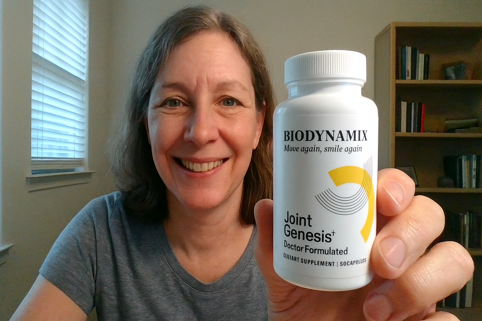 Smiling woman holding a bottle of Joint Genesis supplement